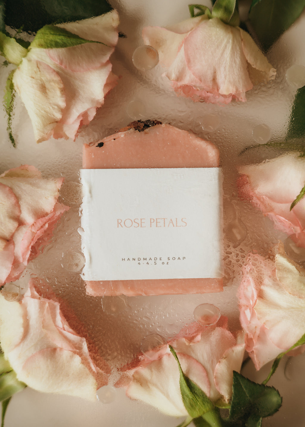 Bar of soap with 'Rose Petals' label surrounded by pink roses