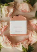 Bar of soap with 'Rose Petals' label surrounded by pink roses